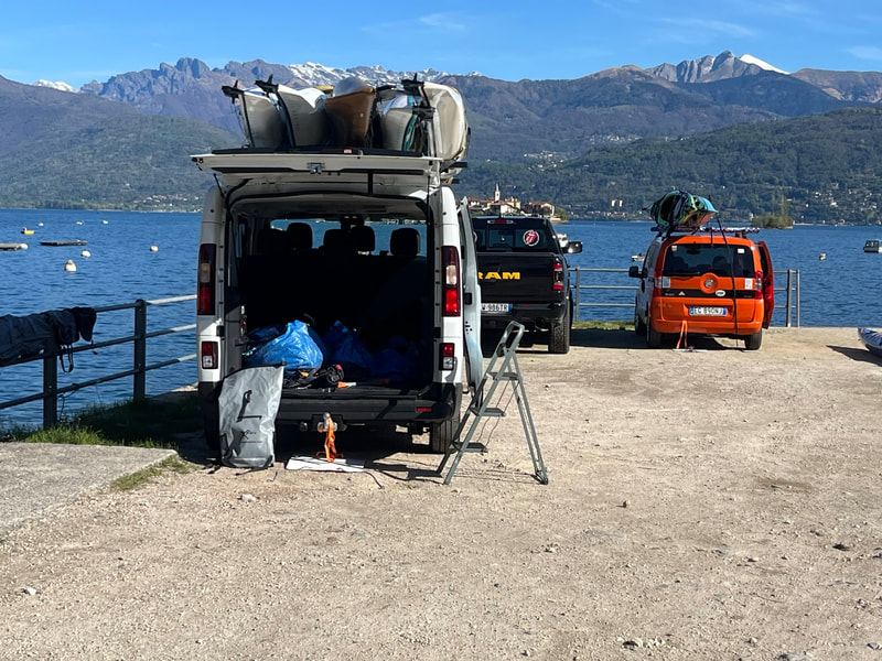Van with kayaks at lake.