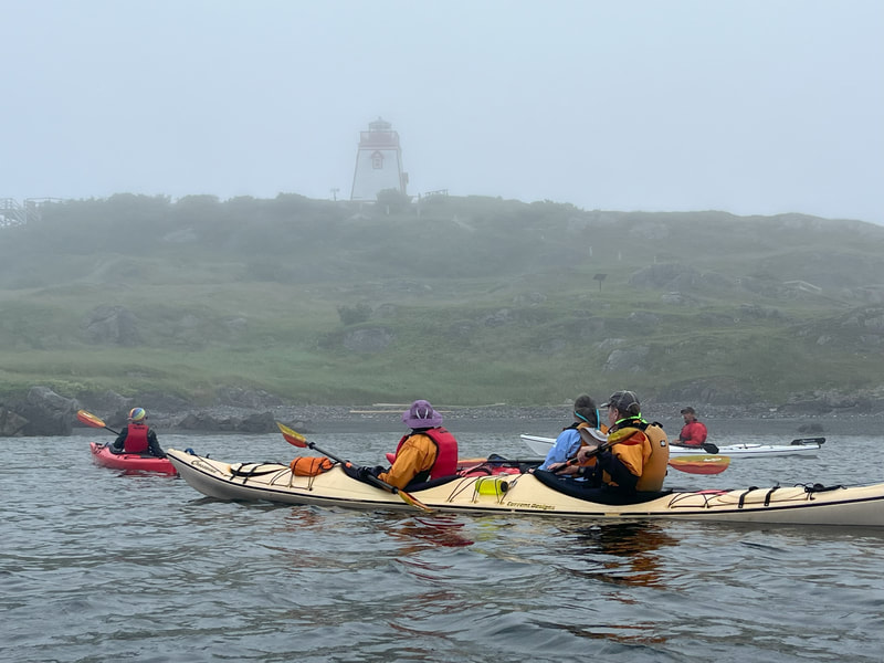 Kayakers looking at lighthouse